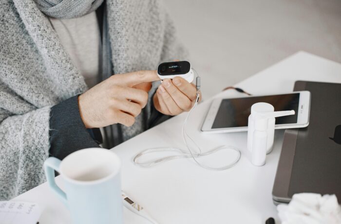 Person checking vital signs with finger monitor